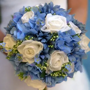 A bridal bouquet collection of white or ivory roses plus blue artificial silk hydrangea