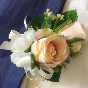 A corsage featuring two blush pink silk roses